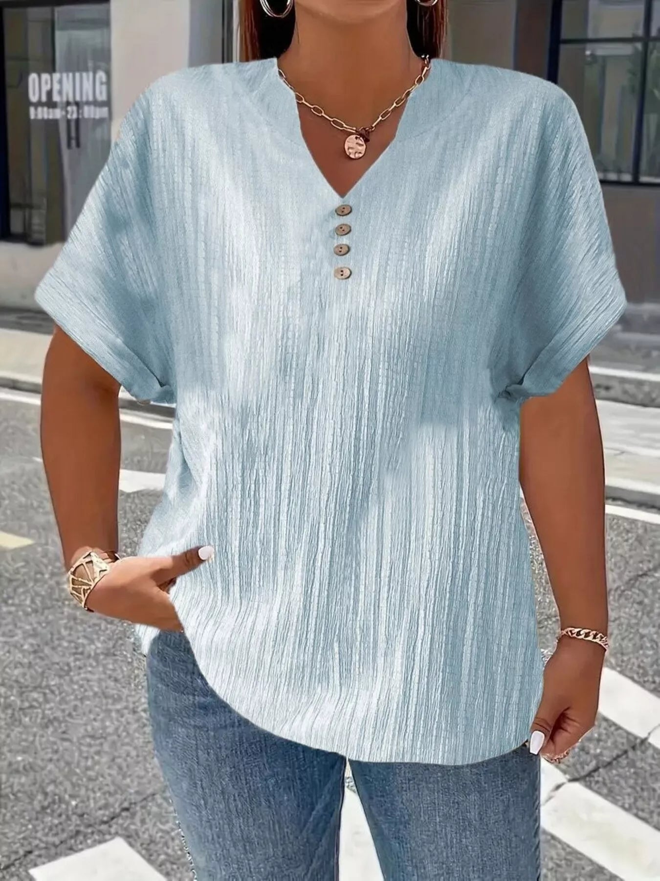 Plus size notched short sleeve textured top with decorative button in 100% polyester, available in sizes 1XL to 5XL