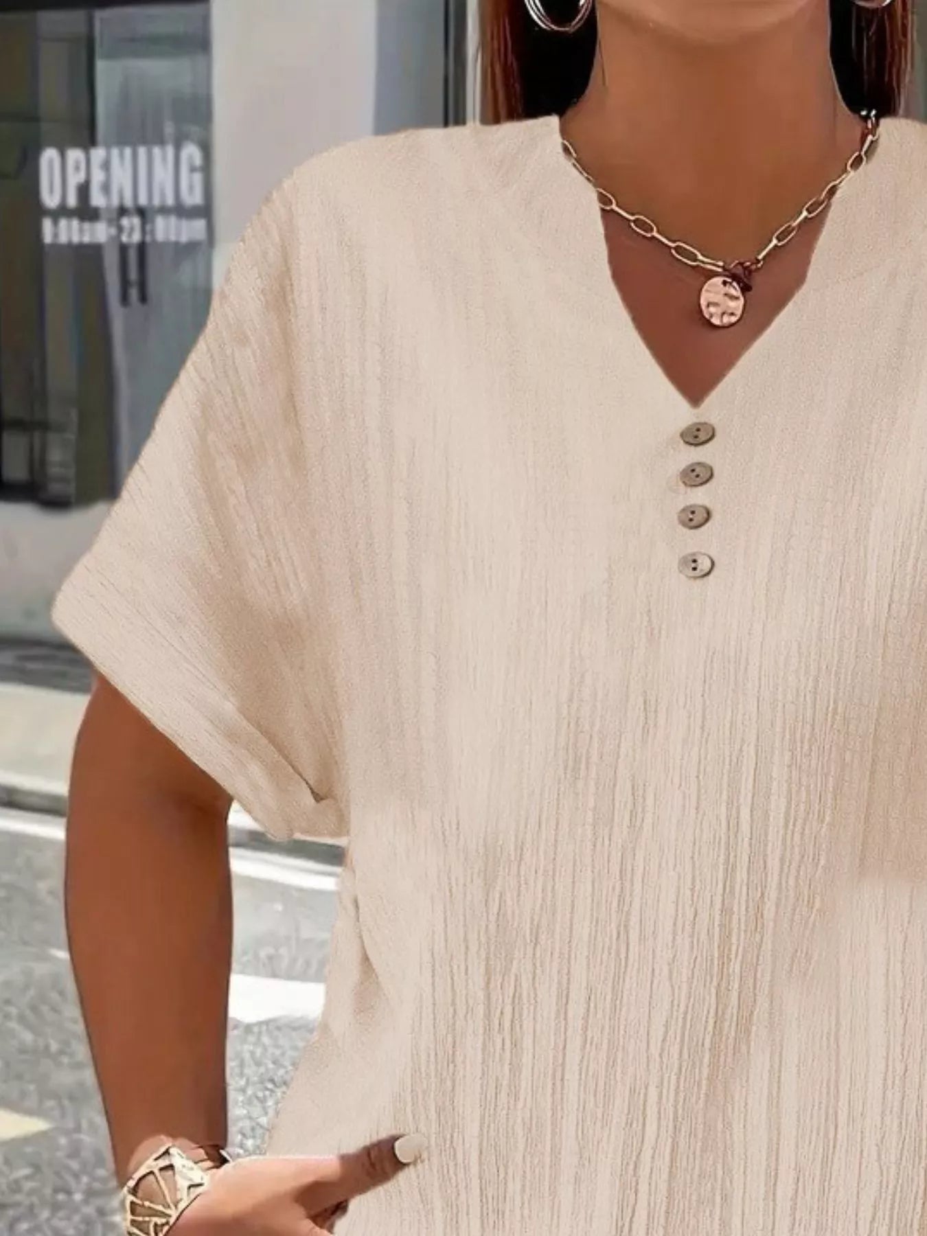 Plus size notched short sleeve textured top with decorative button in 100% polyester, available in sizes 1XL to 5XL